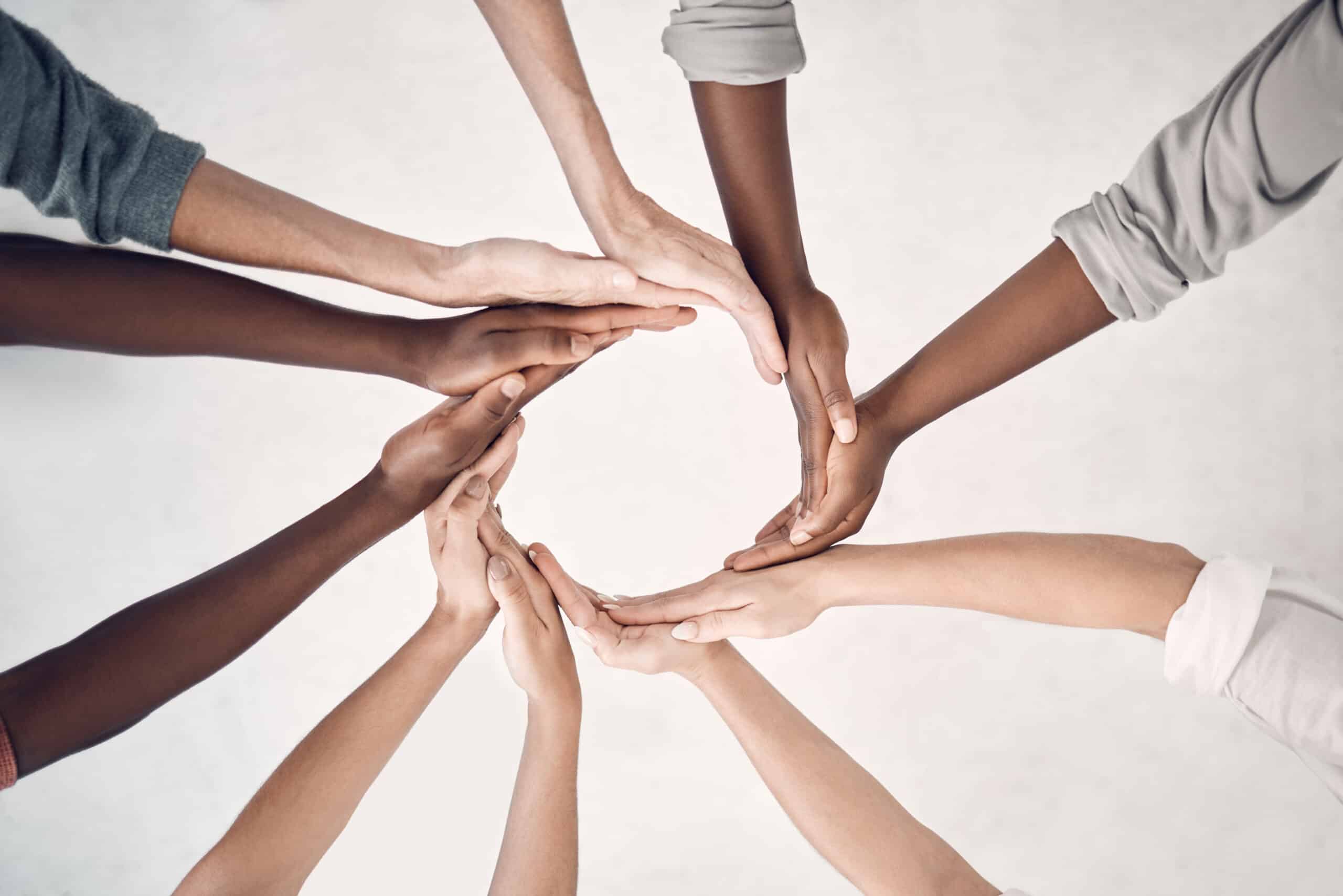 The hands are arranged symmetrically, symbolizing unity, collaboration, and inclusivity